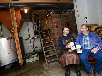 Der aktuelle Vorsitzende der Hausbrauer Thomas Bretscher (links) und  sein Vorgänger Bürgermeister Egon Klöffel prosten sich zu. Am 30. März wird im Gemeindebrauhaus Thundorf wieder angeschürt. Foto: Philipp Bauernschubert