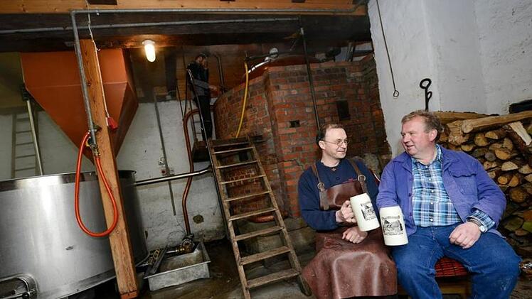 Der aktuelle Vorsitzende der Hausbrauer Thomas Bretscher (links) und  sein Vorgänger Bürgermeister Egon Klöffel prosten sich zu. Am 30. März wird im Gemeindebrauhaus Thundorf wieder angeschürt. Foto: Philipp Bauernschubert