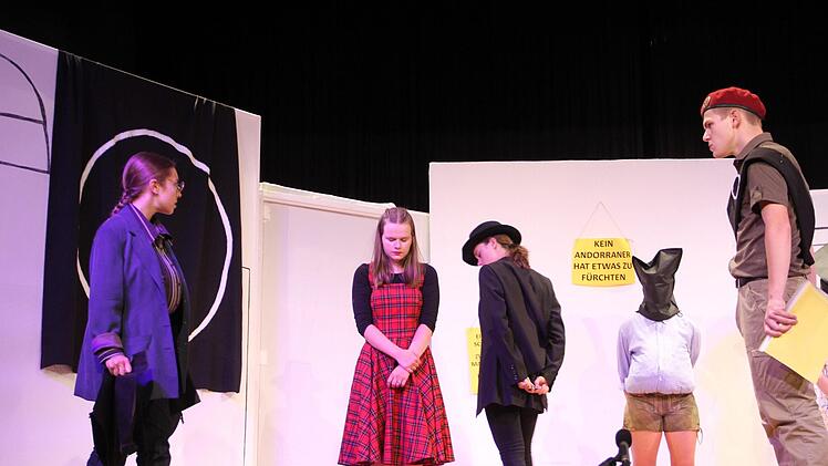Der Judenschauer (3. v. li., Alexander Thiel) schaut sich die Füße von Andri (Lisa Stock) an.