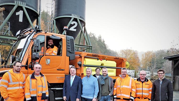 Landrat Klaus Peter Söllner, Straßenmeister Eckhard Schrepfer, Vertreter der Bauverwaltung am Landratsamt und Mitarbeiter der Straßenmeisterei bei der Übergabe des neuen Unimogs.  Foto: Werner Reißaus