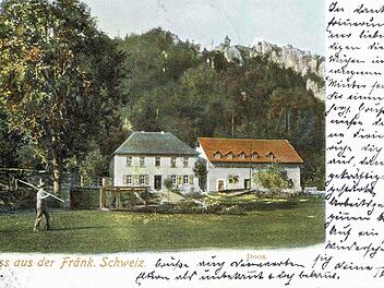 Doos auf einer Postkarte von 1901. Hier ist ein Fischer zu sehen, wie er mit dem Kescher über der Schulter Richtung Wirtshaus läuft. Repros: R. Löwisch