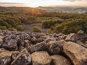 In seinem Rhön-Kalender "Rhönheimat 2021" präsentiert Jürgen  Hüfner jahreszeitliche Impressionen aus dem "Land der Offenen Fernen".   Hier das Titelbild mit dem Schafstein-Blockmeer bei Sonnenuntergang.  Foto: Jürgen Hüfner