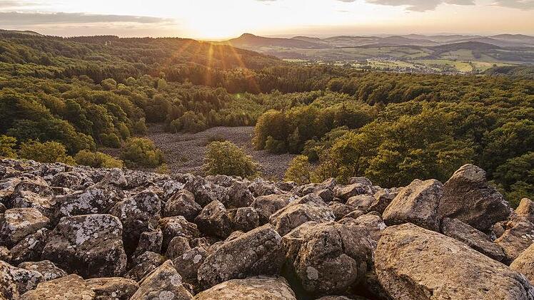 In seinem Rhön-Kalender "Rhönheimat 2021" präsentiert Jürgen  Hüfner jahreszeitliche Impressionen aus dem "Land der Offenen Fernen".   Hier das Titelbild mit dem Schafstein-Blockmeer bei Sonnenuntergang.  Foto: Jürgen Hüfner