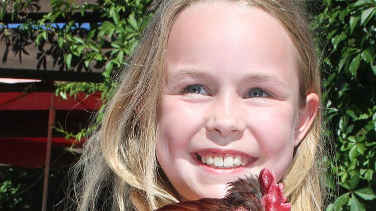 Elina Wyckoff schickte ihren Mischlingshahn ins Rennen und wurde stolze Siegerin: 45 Mal kr&auml;hte der Mix aus Zwergseidenhuhn und Zwergsussex. Die Familie hat insgesamt f&uuml;nf H&auml;hne in Menchau.Sonny Adam