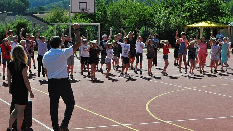 Zum Hit  "Tage wie diese" rockten die Kinder zusammen mit Alois Brandl und Silke Feulner  auf dem Schulsportgelände.