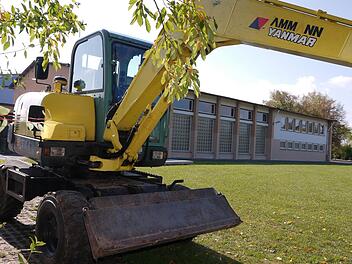 Schaut fast so aus, als ob der Bau gleich losgeht: Der Bagger vor der sanierungsbedürftigen Schulturnhalle in Weidhausen steht allerdings wegen Arbeiten am Außengelände der Schule da. Wie groß der Anbau an der Halle sein muss, war  großes Streitthema bei der Gemeinderatssitzung.