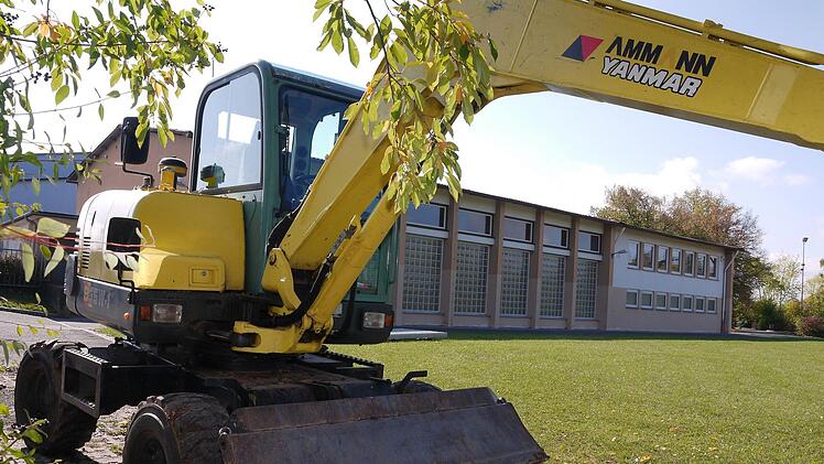 Schaut fast so aus, als ob der Bau gleich losgeht: Der Bagger vor der sanierungsbedürftigen Schulturnhalle in Weidhausen steht allerdings wegen Arbeiten am Außengelände der Schule da. Wie groß der Anbau an der Halle sein muss, war  großes Streitthema bei der Gemeinderatssitzung.