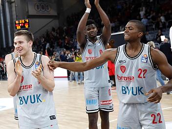 Die Würzburger (von links) Nils Haßfurther, Junior Etou und Cameron Wells lassen sich von den Fans feiern. Foto: Daniel Löb