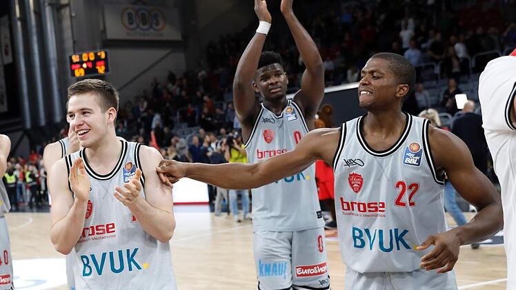 Die Würzburger (von links) Nils Haßfurther, Junior Etou und Cameron Wells lassen sich von den Fans feiern. Foto: Daniel Löb