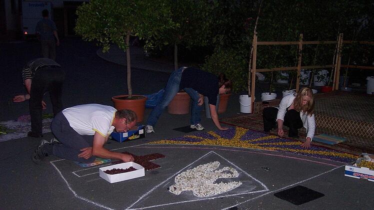 Schon nachts legen die Stadtsteinacher den Teppich - der Kirchplatz wird von Autoscheinwerfern erleuchtet. Oder Taschenlampen.