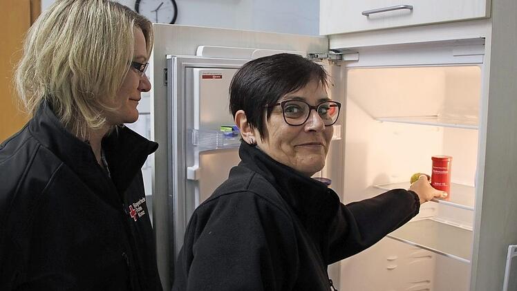 Simone Gilley (links) und Ingrid Böllner vom Rot-Kreuz-Kreisverband Haßberge zeigen, wie die Rotkreuz-Dose aufbewahrt werden soll: Im Kühlschrank - der ist in fast jedem Haushalt vorhanden und leicht zu finden.