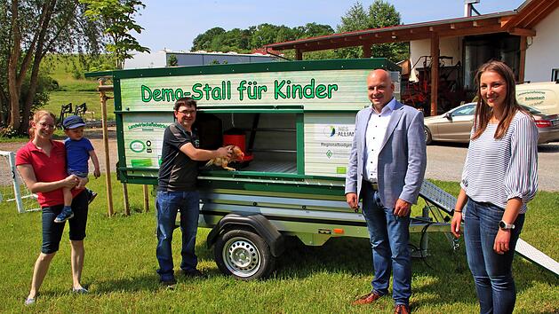 Symbolisch sperrt Andreas Schlembach (dritter von links) das erste Huhn in  seinen neuen Demo-Stall. Links seine Frau Anna und sein Sohn Stefan. Rechts  Bürgermeister Michael Kastl und Allianzmanagerin Hanna Braungart. Foto:  Dieter Britz