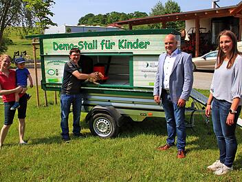 Symbolisch sperrt Andreas Schlembach (dritter von links) das erste Huhn in  seinen neuen Demo-Stall. Links seine Frau Anna und sein Sohn Stefan. Rechts  Bürgermeister Michael Kastl und Allianzmanagerin Hanna Braungart. Foto:  Dieter Britz