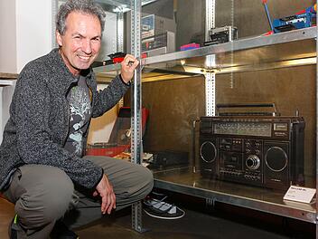 Alexander Mayer kauert im Rundfunkmuseum der Stadt Fürth vor dem Stereo-Radiorekorder RR 1140 SL der Firma Grundig. Das Gerät kam 1981 auf den Markt. Foto: Matthias Hoch