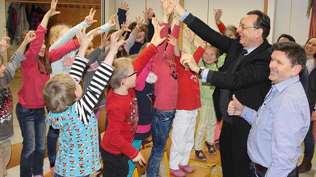 Auf die Frage nach gesundem Essen reckten sich spontan alle Sch&uuml;lerh&auml;nde in die H&ouml;he. Rektor Alois Brandl und der stellvertretende Direktor der AOK Schweinfurt, Peter Scheder (von rechts) hatten sichtlich Freude asm Elan und an den Antworten der Buben und M&auml;dchen.  Foto: Helmut Will