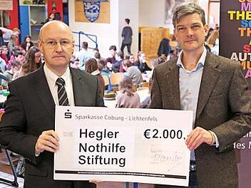 Stiftungsvorstand Stephan Franke (links) überreicht in der Aula der Schule einen symbolischen Scheck an den Vorsitzenden des Vereins der Freunde und Förderer des Meranier-Gymnasiums, Tim Birkner. Foto: privat