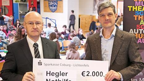 Stiftungsvorstand Stephan Franke (links) überreicht in der Aula der Schule einen symbolischen Scheck an den Vorsitzenden des Vereins der Freunde und Förderer des Meranier-Gymnasiums, Tim Birkner. Foto: privat