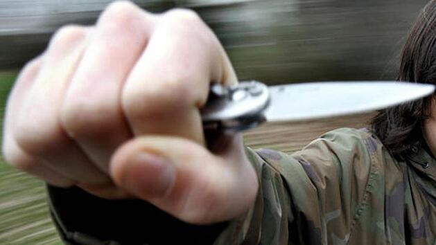 Mann mit Taschenmesser in der Hand