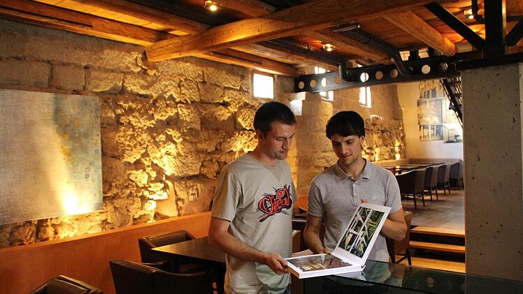 Felix (links) und Simon Wasel mit dem Buch, in dem der Ausbau der Alten Mälzerei dokumentiert ist.  Fotos: Andreas Dorsch