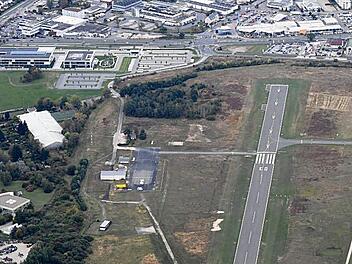 Die Zaunanlage wird den gesamten Bamberger Flugplatz umschließen und die große Freifläche gegenüber der Stadt, sowie den Stadtteilen Gartenstadt (links) und Kramers-feld (rechts) abschirmen. Links oben: das neue Brose-Verwaltungszentrum   Foto: Ronald Rinklef