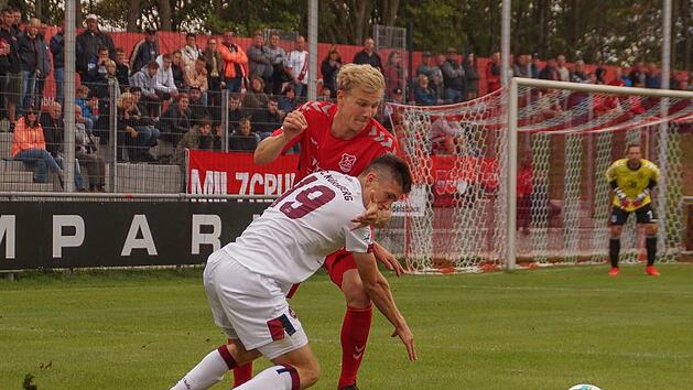 Aubstadts Verteidiger Steffen Behr (hinten, rotes Trikot) hatte mit dem N&uuml;rnberger Linus Rosenl&ouml;cher alle H&auml;nde voll zu tun. Foto: Rudi D&uuml;mpert