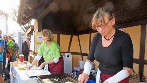 Elvira Reinhardt (rechts) und Erika Hellmuth backen Kartoffelpuffer.
