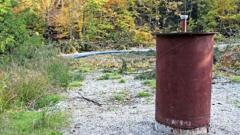 Die Metallkappen auf den Brunnen im Wald werden bald durch Betoneinfassungen ersetzt. Im Hintergrund liegen schon die Wasserrohre. Foto: Andreas Dorsch