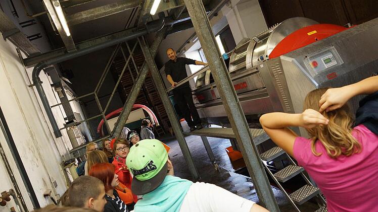 Thomas Lange zeigt den Schülern die Traubenpresse. Foto: Arkadius Guzy