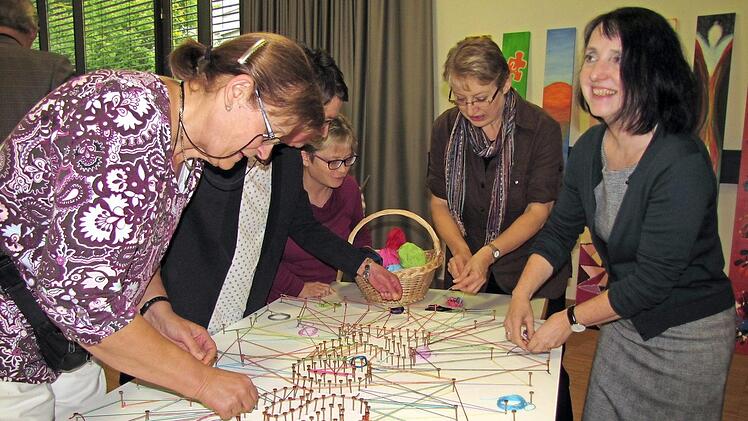 Da entsteht ein symbolisches Netzwerk rund um die Kontaktstelle Selbsthilfe. Sabine Feuerbach-Hein und Sabine Doerenkamp-Steiner (Zweite und Erste von rechts) legen mit Hand an.  Foto: Martin Koch