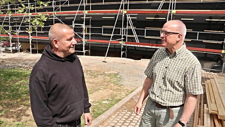 Oliver Dünisch (rechts) spricht mit einem Arbeiter, der die Holzverschalung am Schülerwohnheim mit anbringt.Helmut Will