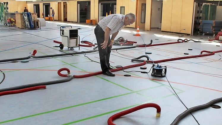 Günter Brehm inspiziert die Löcher in der Sporthalle. Foto: Andreas Dorsch