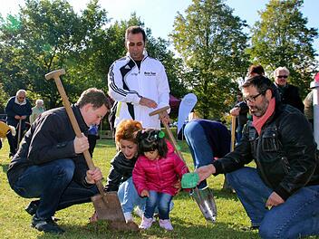 Premiere bei der 5. Krokus-Pflanzaktion im Bad Rodacher Kurpark: Um die 10 000 neuen Zwiebeln in die Erde zu bringen, hatte Bürgermeister Tobias Ehrlicher (links) erstmals auch in der Kurstadt untergebrachte Flüchtlinge um Hilfe gebeten. Die kleine Donya Alipoor sowie ihre Eltern Fatime und Morteza aus dem Iran halfen begeistert mit, auch zur Freude von Stadtrat Rainer Möbus (rechts).Foto: Bettina Knauth