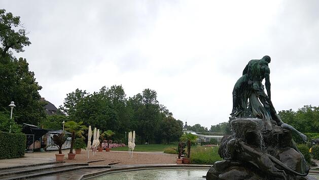 Bei Regen schaut auch der sch&ouml;nste Garten trist aus. Heute soll der "Stadtstrand" direkt beim Sintflutbrunnen &ouml;ffnen, und die Sonnenschirme werden hoffentlich ihren Zweck erf&uuml;llen k&ouml;nnen. Loungem&ouml;bel und Liegest&uuml;hle laden zum Niederlassen ein, und Kinder k&ouml;nnen im Sand buddeln. Ge&ouml;ffnet ist von 11 bis 22 Uhr. Foto: Simone Bastian
