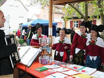 Die Regnitztaler Trachtengruppe am Stand der Arbeitsgemeinschaft Volksmusik Oberfranken, an dem Hans-Dieter Ruß traditionelles Liedgut unters Volk bringt.  Fotos: Evi Seeger