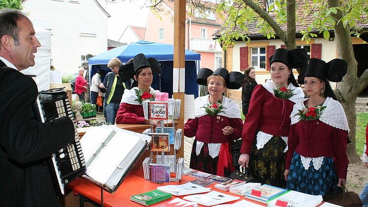Die Regnitztaler Trachtengruppe am Stand der Arbeitsgemeinschaft Volksmusik Oberfranken, an dem Hans-Dieter Ruß traditionelles Liedgut unters Volk bringt.  Fotos: Evi Seeger