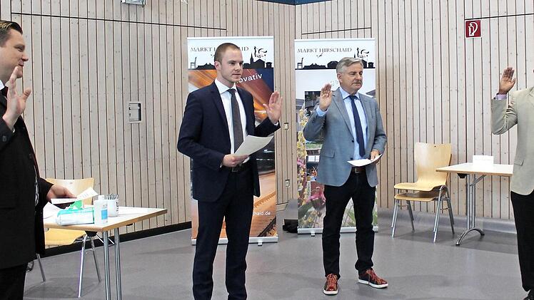 Acht neuen Marktgemeinderäten nahm Bürgermeister Homann (rechtes Bild, ganz rechts) den Eid ab, mit Rücksicht auf den gebotenen Schutzabstand in zwei "Raten": Christian Neundörfer (CSU), Martin Wünsche