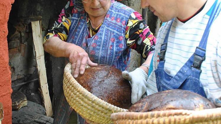 Paula Geyer bäckt Brot im Holzbackofen. Das Jubiläumsfest kann kommen.
