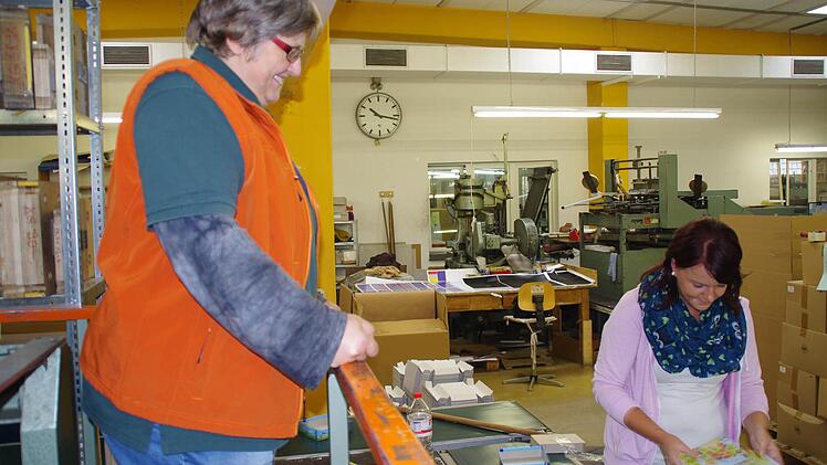 Firmen-Mitinhaberin Johanna Spindler schaut sich in der Produktion um, wo Romy Schwarz gerade Spieleschachteln befüllt. Foto: Marco Meißner