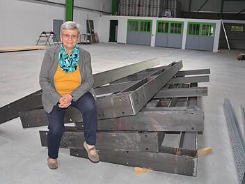 Hilda Albert sitzt auf einer Stahlkonstruktion. Diese ist Teil eines riesigen Regales, das an der Hallenwand platziert wird.  Foto: Kathrin Kupka-Hahn