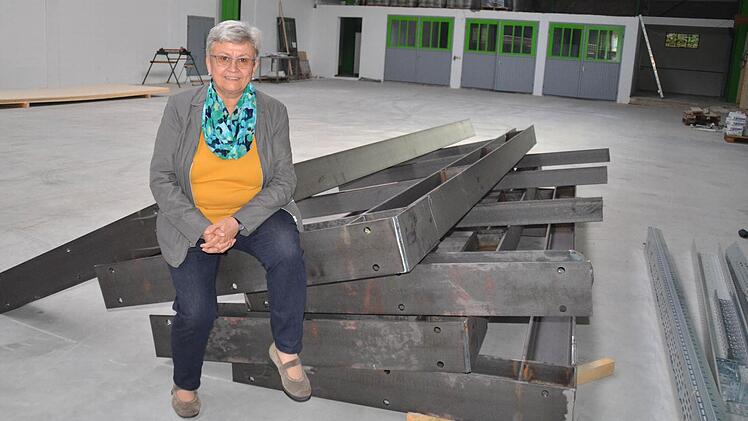 Hilda Albert sitzt auf einer Stahlkonstruktion. Diese ist Teil eines riesigen Regales, das an der Hallenwand platziert wird.  Foto: Kathrin Kupka-Hahn