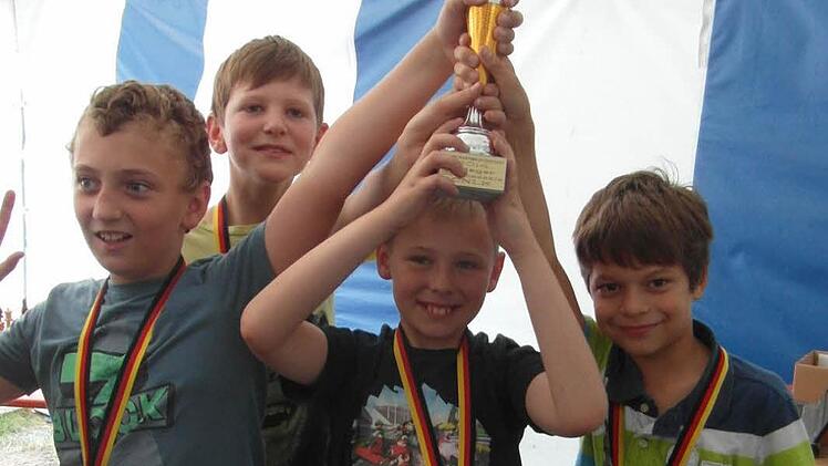 Michael Gutbrod, David Müller, Robin Beetz und Tarek Becic jubeln über den gewonnenen Pokal bei der U12-Mannschaftsmeisterschaft des Schachkreises CNLK. Foto: Hans Neuberg