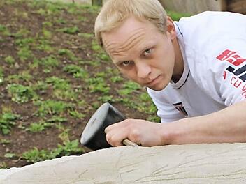 Steinmetzmeister Stefan Böttcher verschönert das Familiengrundstück mit steinernen Kunstwerken. Gerade klopft er ein Weinblatt aus dem Sandstein.  Foto: Katja Kölbl