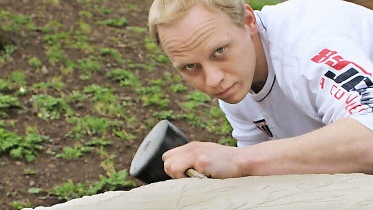 Steinmetzmeister Stefan Böttcher verschönert das Familiengrundstück mit steinernen Kunstwerken. Gerade klopft er ein Weinblatt aus dem Sandstein.  Foto: Katja Kölbl