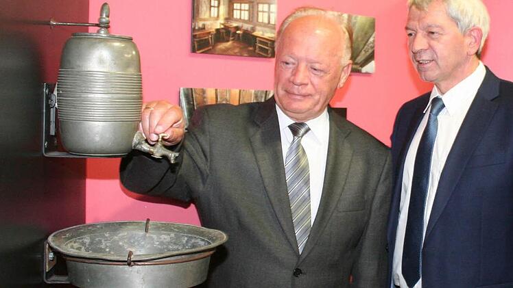War das so etwas wie ein heutiges Waschbecken? Der Landrat des polnischen Partnerlandkreises Jelenia Gora war unter den Gästen der Ausstellungseröffnung und erkundet gerade ein Exponat. Neben ihm der Bamberger Landrat Johann Kalb. Fotos: Evi Seeger