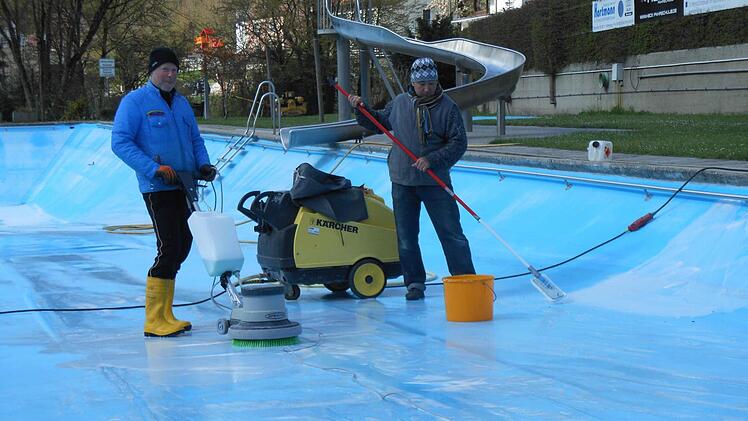Bademeister Frank Hettmannsperger und Konstantin Fedotov haben mit dem Beckenputzen in Gr&auml;fenberg schon angefangen, als es noch kalt war.  Foto: Jennifer Brechtelsbauer