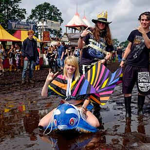 Metal-Fans laufen am 04.08.2016 in Wacken (Schleswig-Holstein) auf dem Gelände des Wacken Open Air durch den Matsch. Das Gelände des nach Veranstalterangaben größten Metal Festivals ist nach starken Regenfällen mit Schlamm überzogen.