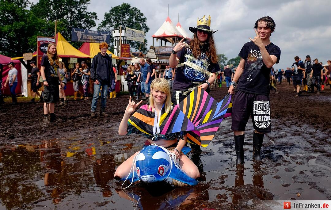 Metal-Fans laufen am 04.08.2016 in Wacken (Schleswig-Holstein) auf dem Gelände des Wacken Open Air durch den Matsch. Das Gelände des nach Veranstalterangaben größten Metal Festivals ist nach starken Regenfällen mit Schlamm überzogen.