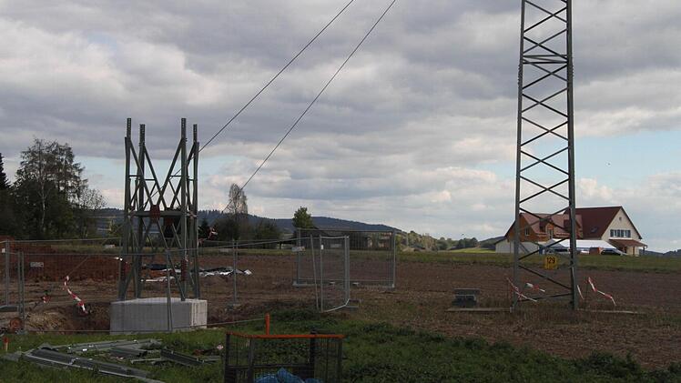 Links das Grundgerüst des neuen, rechts der alte Mast. Letzter wird abgebaut, wenn die Stromleitungen auf den Neuen umgelegt sind.