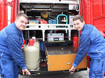 Sebastian Knauer und Tobias Zollnhofer zeigen bei geöffneten Hecktüren des neuen Brandschutzerziehungs-Fahrzeuges, wie die Ausstattung darin sicher verstaut ist. Foto: Popp