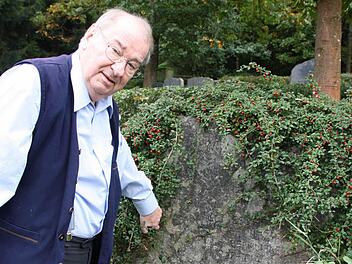 Helmut Marx am Grabstein der Familie Putz. Mittlerweile haben Mitarbeiter des Bauhofes den Findling frei geschnitten und gereinigt, demnächst soll noch die Schrift nachgezeichnet werden.  Fotos: Ralf Ruppert/Helmut Marx